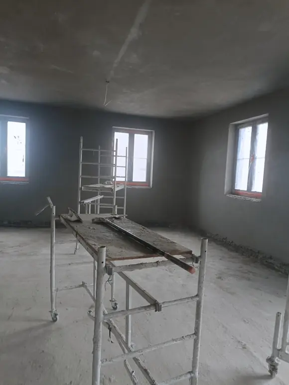 Pomieszczenie z rusztowaniem przy ścianie, prace tynkarskie w toku